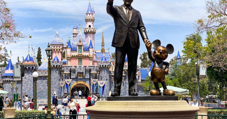 Walt Disney and Mickey Mouse statue in front of Sleeping Beauty Castle at Disneyland Park.
