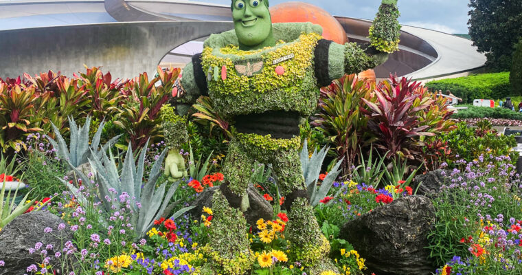 Topiary of Buzz Lightyear surrounded by colorful flowers in front of Mission: SPACE attraction at EPCOT in Walt Disney World.