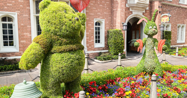 Topiaries of Winnie the Pooh and Rabbit among a bed of flowers in the United Kingdom Pavilion at EPCOT in Walt Disney World.